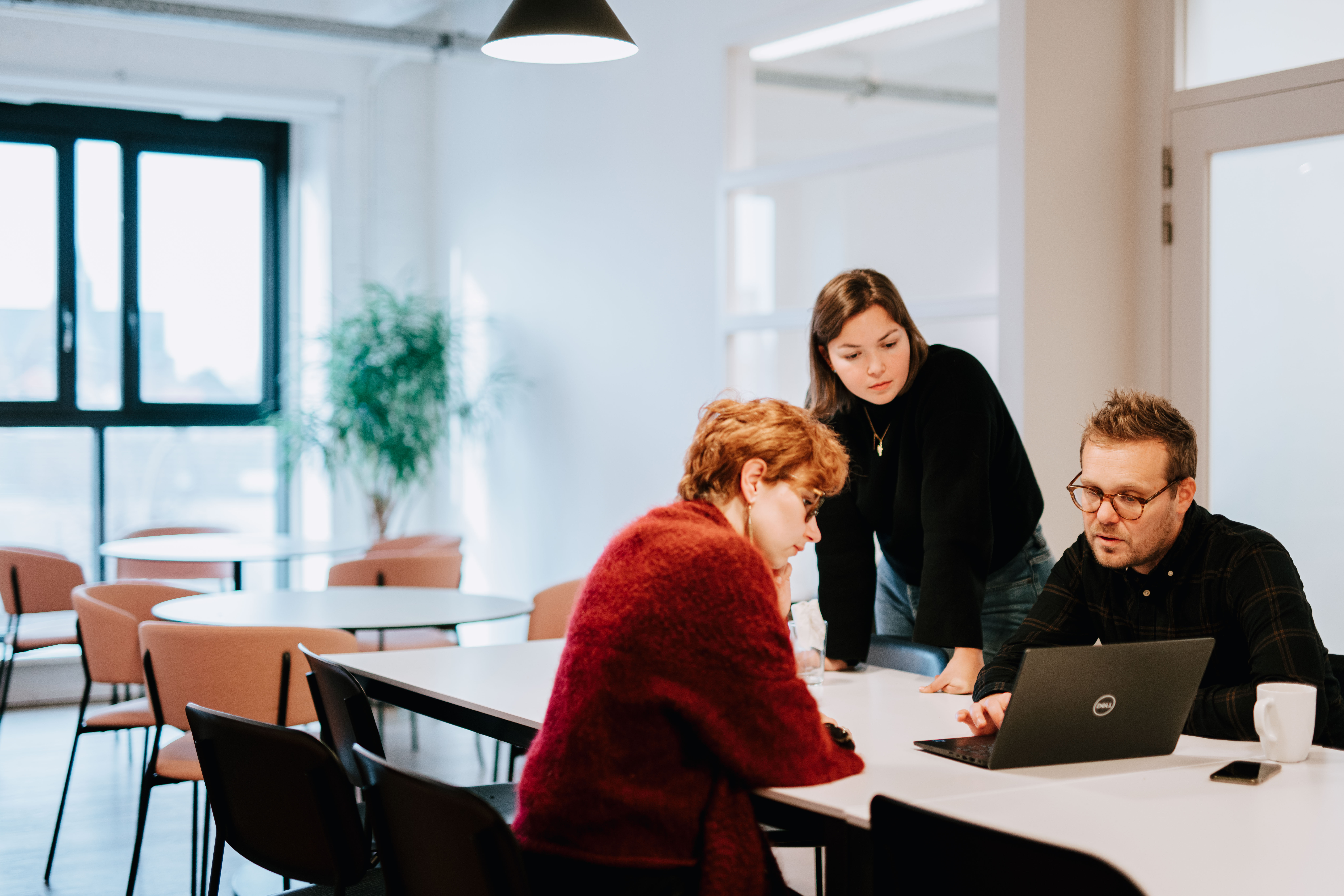 Three people having a casual meeting in the kitchen