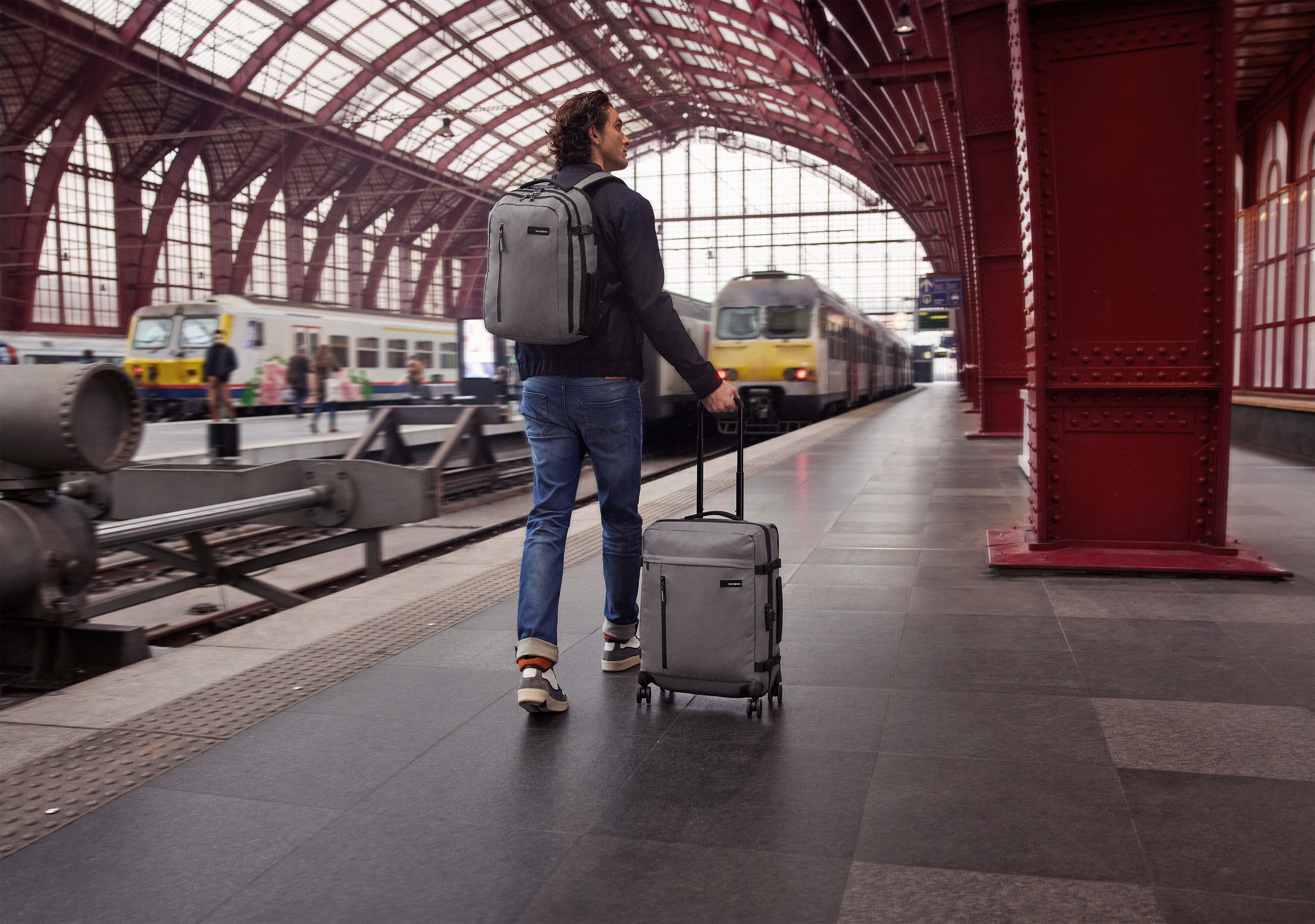 Person walking in Antwerp-Central station with Samsonite backpack and trolley