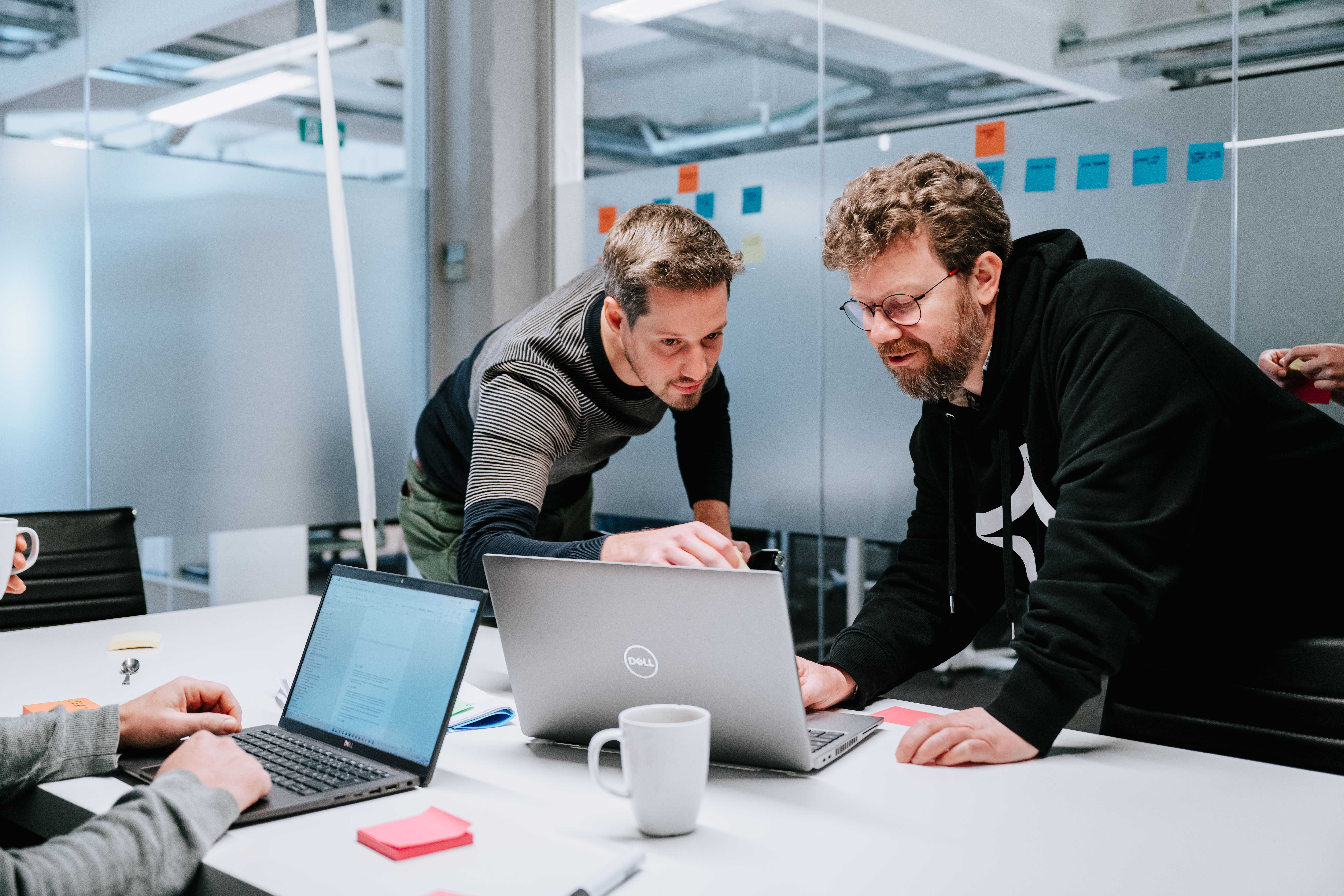 A person explaining something to his colleague on a laptop screen