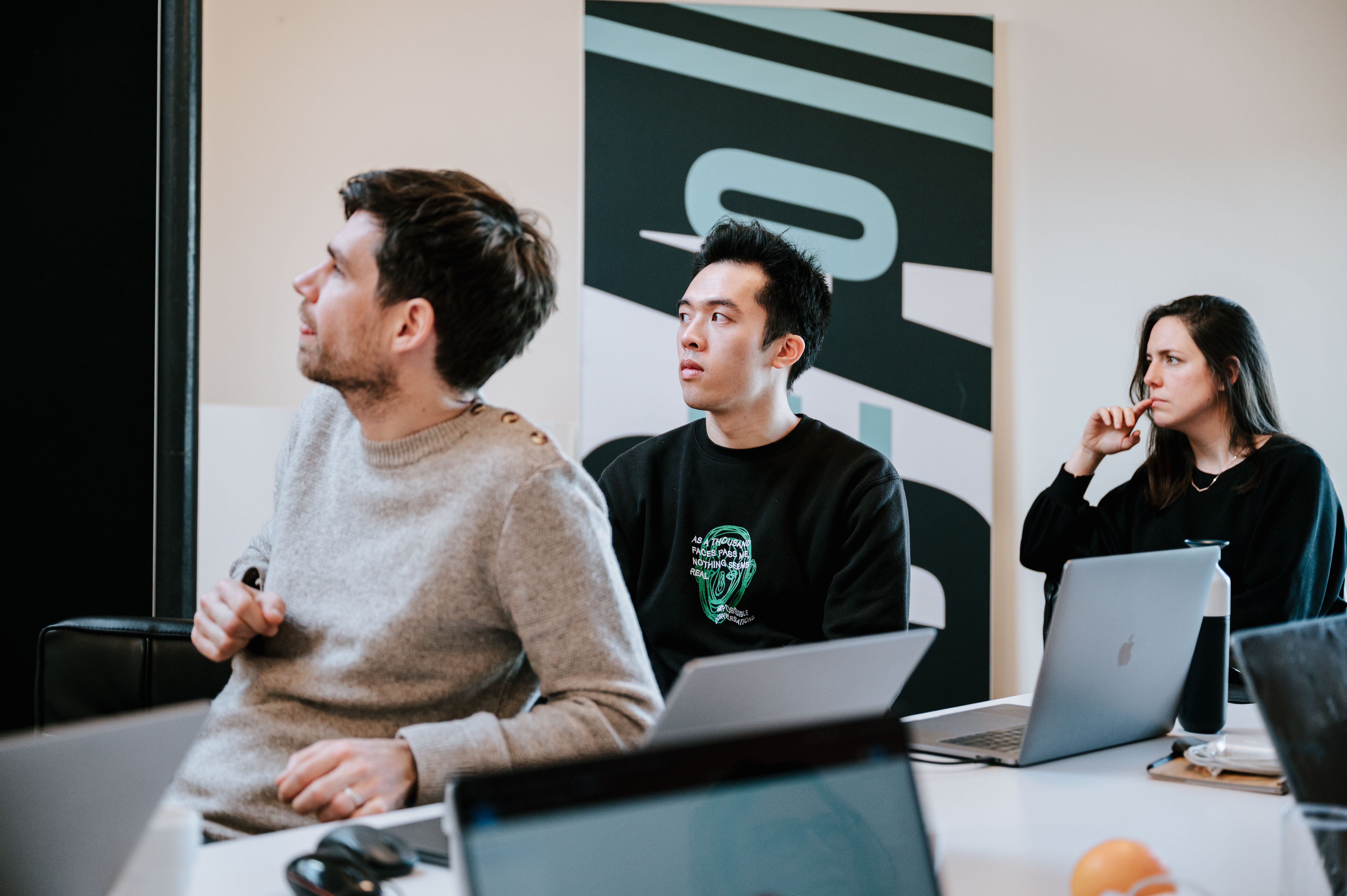 Three people looking focused across the room