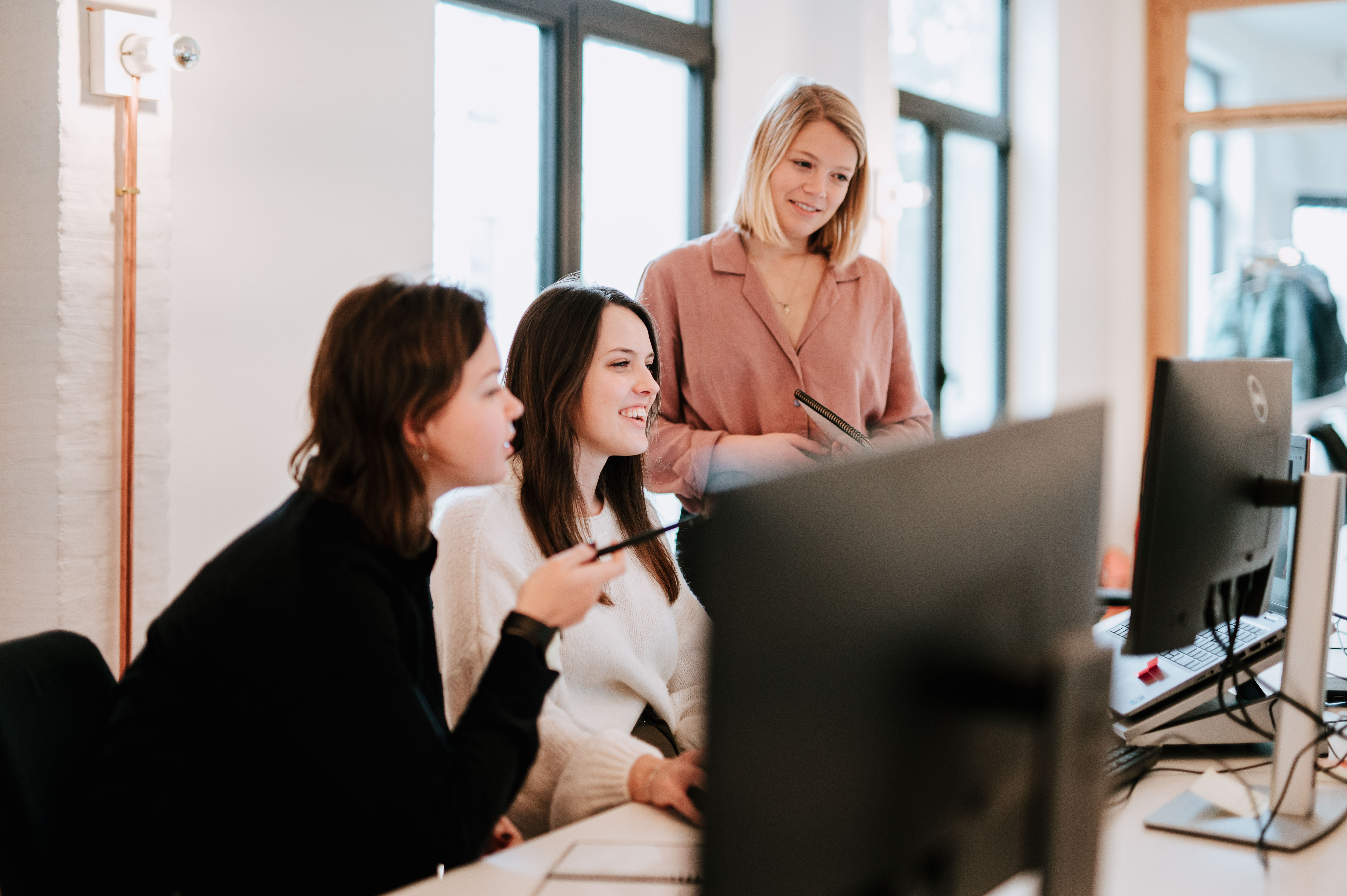 Three people discussing something on the computer screen