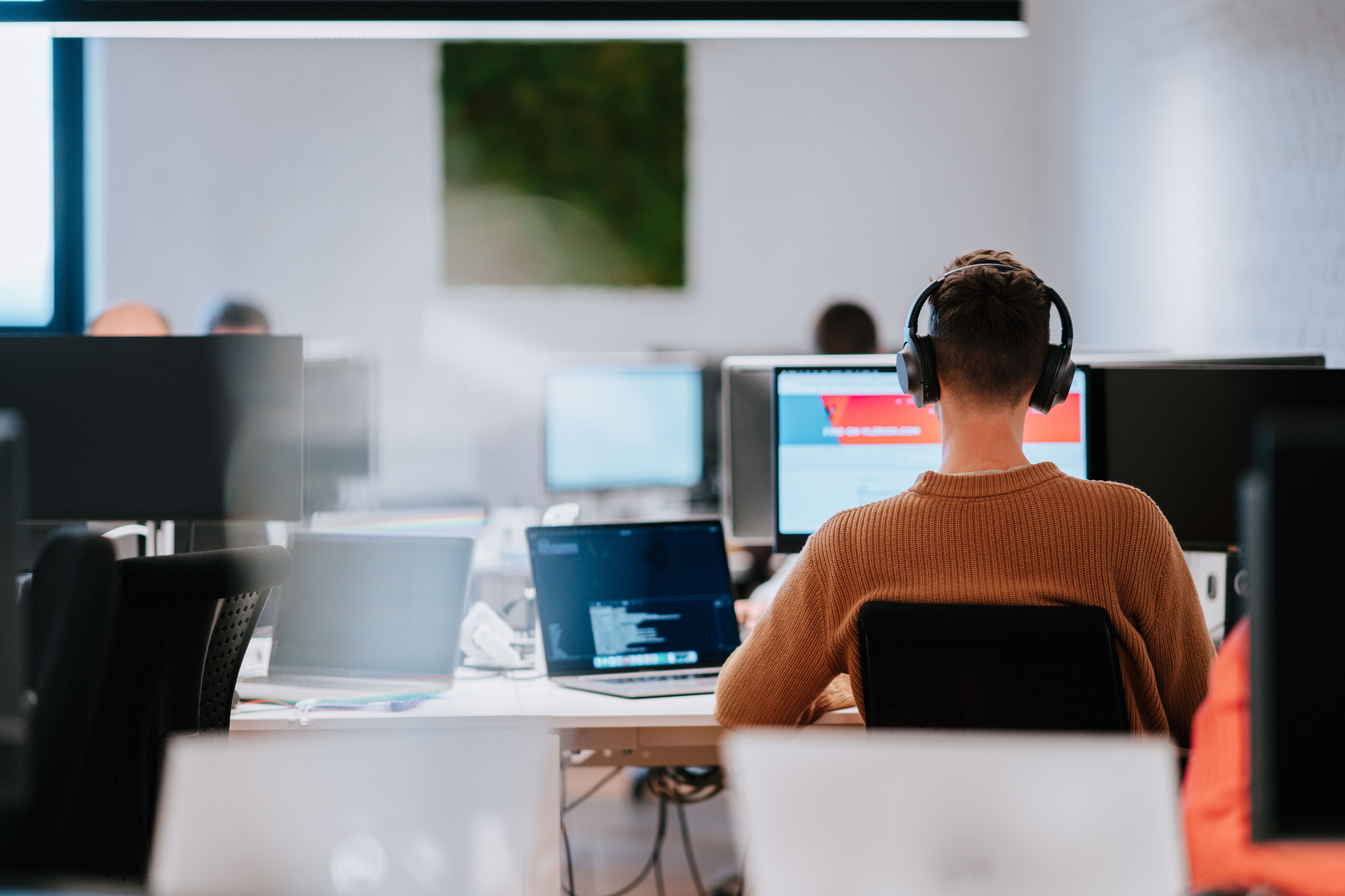 A person working in the office with headphones on