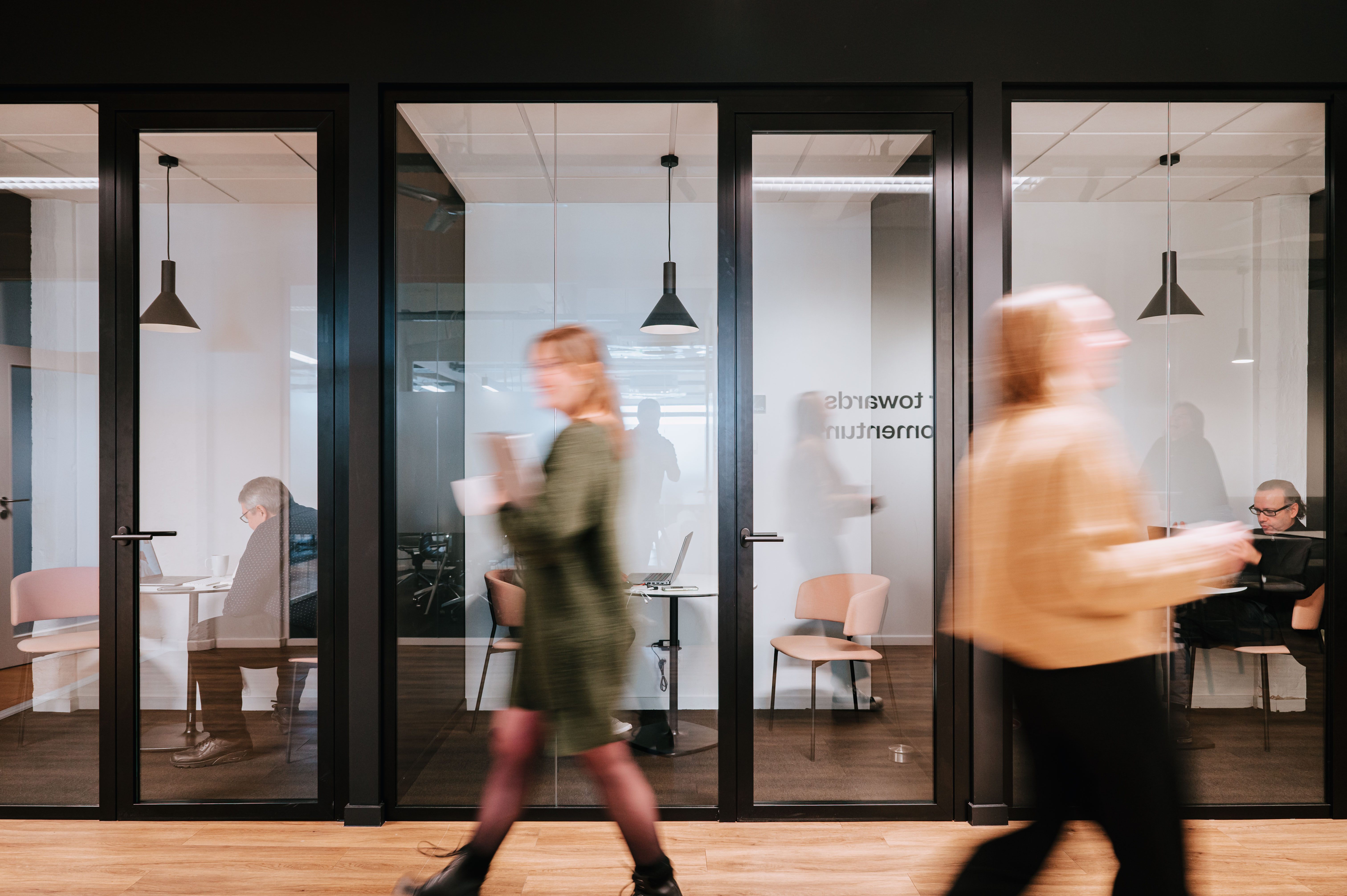 Wide shot of the silent booths while people are passing